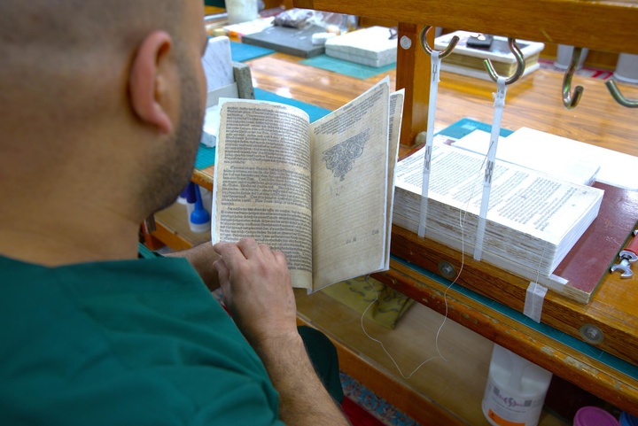 قسم الشؤون الفكرية يواصل ترميم كتاب الإنجيل المكتوب باللغة الألمانية
