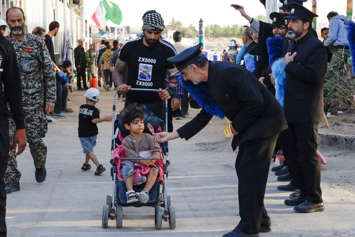 Imam Javad Mukib serves pilgrims walking to Imam Reza Shrine