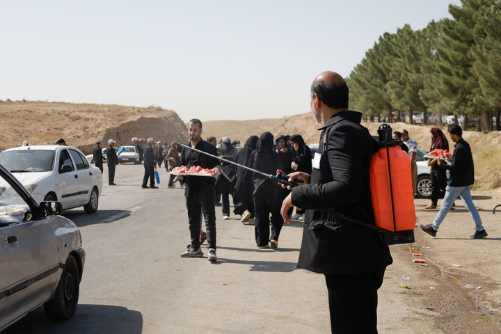 Imam Javad Mukib serves pilgrims walking to Imam Reza Shrine