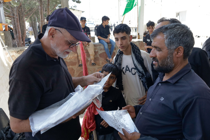 Imam Javad Mukib serves pilgrims walking to Imam Reza Shrine