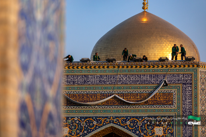 تعویض پرچم گنبد و نصب کتیبه‌های عزای امام حسن عسکری(ع) در حرم مطهر رضوی